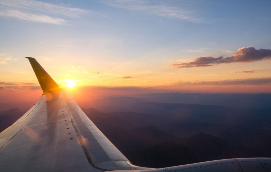 Beautiful sunset view from an airplane window showcasing vivid colors over the mountains.