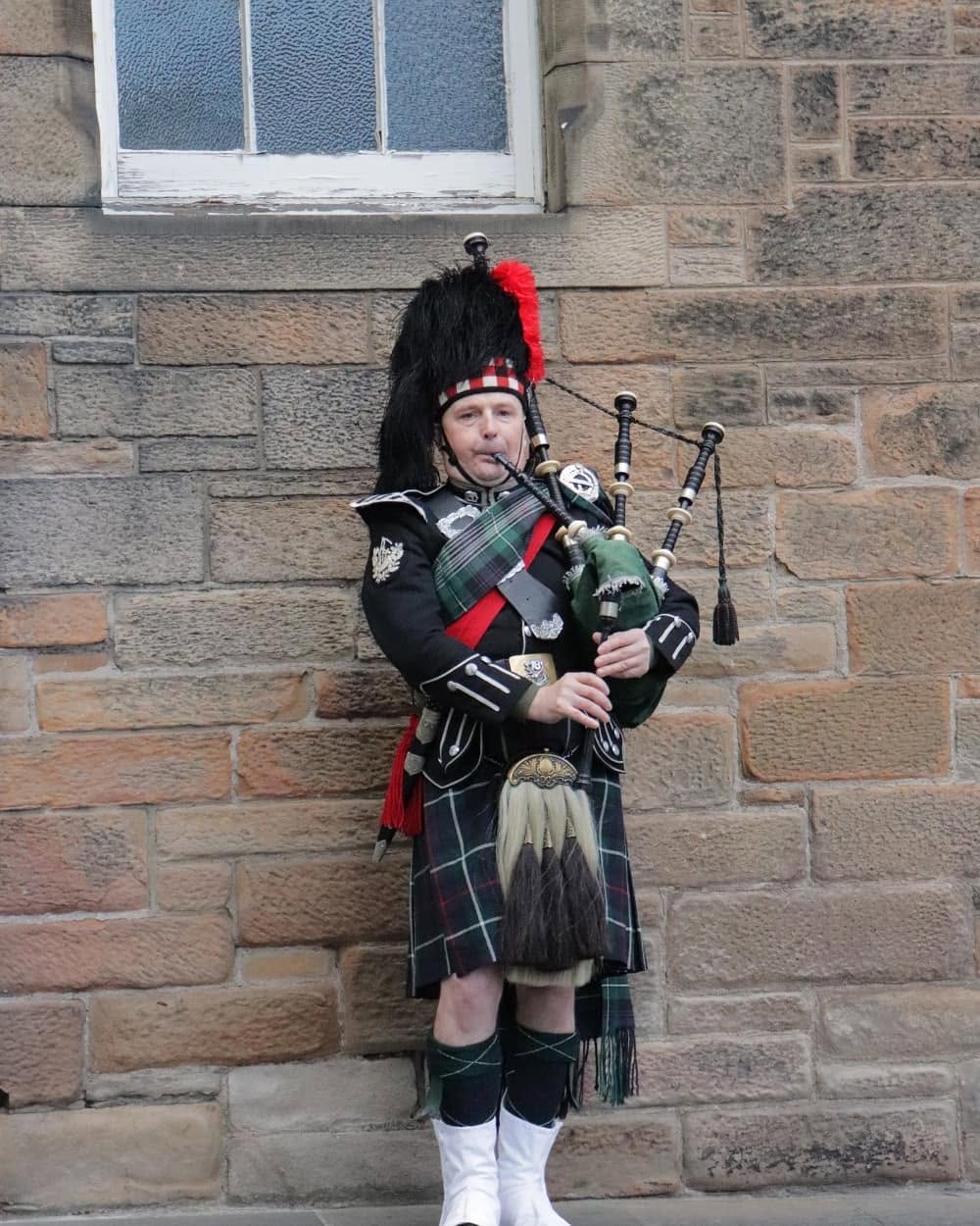 A bagpiper in full traditional Scottish dress