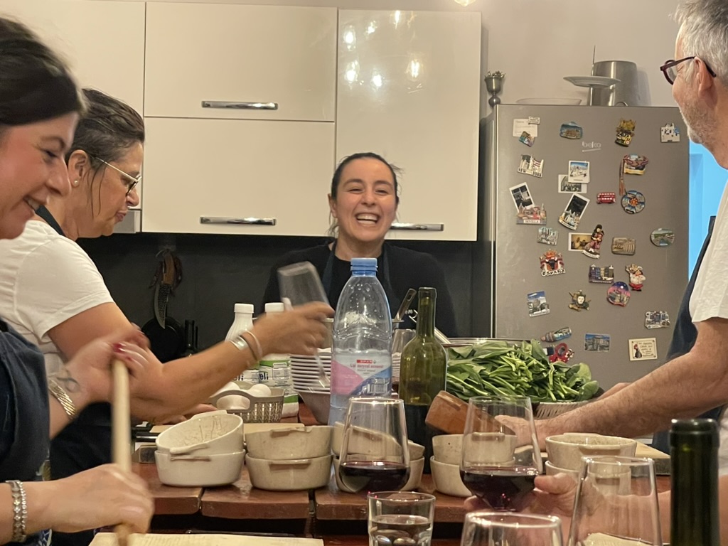Tirana Cooking Class - Sindi sharing wine with guests at the table