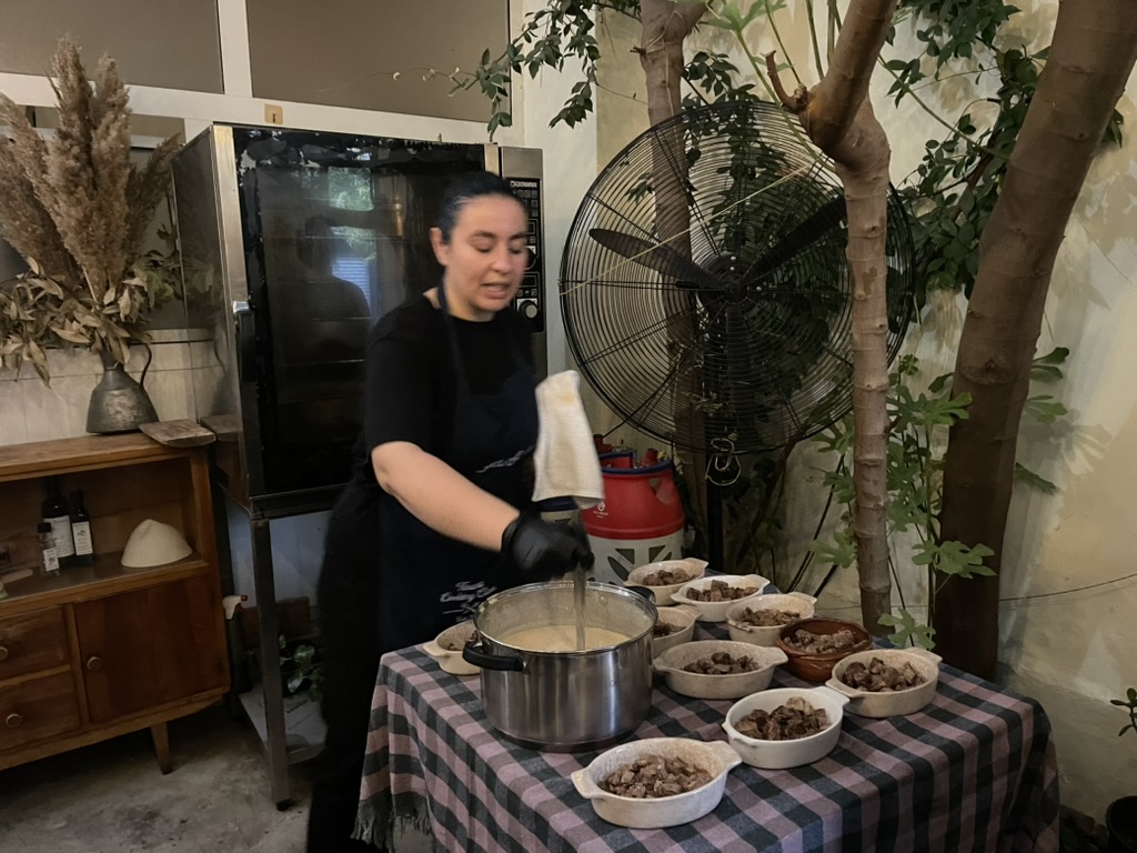 Tirana Cooking Class - Sindi pouring yogurt sauce over tave kosi